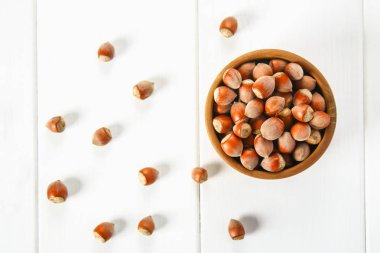 Beyaz ahşap bir masa üzerinde bir ahşap kase fındık fındık. Superfood.