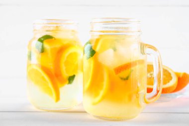 Turuncu Detoks su mason kavanoz bir beyaz tahta masada. Sağlıklı gıda, içecekler.