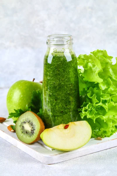 Зелені коктейлі з петрушки, салату, ківі, яблука в пляшці на — стокове фото