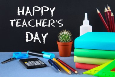 Bir kara tahta üzerinde metin tebeşir: mutlu öğretmenin gün. Okul malzemeleri, ofis, kitaplar, elma.