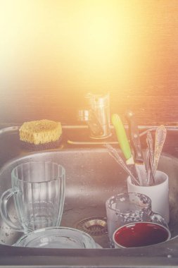 Köpük yıkama için bekleyen Lavaboda kirli yemekleri. Kupalar, tabak, çatal bıçak takımı.
