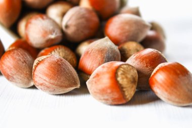 Beyaz ahşap bir masa üzerinde dağınık ceviz fındık.