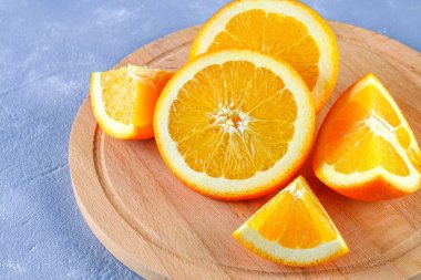 Portakal dilimleri beton gri arka plan üzerinde ahşap bir gemide. Sağlıklı gıda.