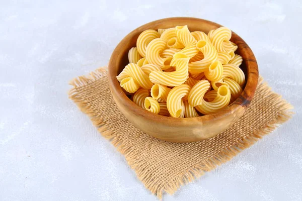 Raw Pasta Cavatappi or Cellentani on a gray table. — Stock Photo, Image