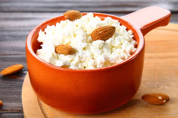 Ricotta fatta in casa con mandorle e uvetta in una ciotola su un tavolo di legno . — Foto Stock