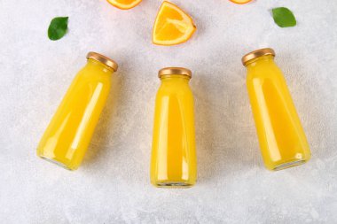 Cam şişe portakal dilimleri ve gri masa lambası üzerine sarı boruları ile taze portakal suyu ile. Üstten Görünüm. Düz Lay.