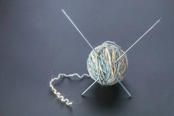 Uma bola de lã com agulhas de tricô e meias em uma mesa cinza. Agulha . — Fotografia de Stock