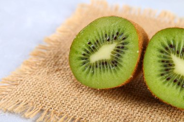 Kivi dilimler halinde gri bir tablo üzerinde kesin. Sağlıklı gıda.