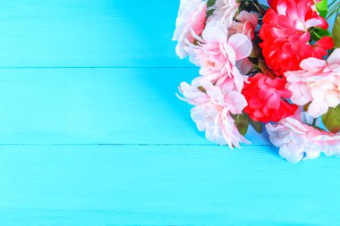 Pembe peonies mavi ahşap bir masa üzerinde. Kartpostal tatil için. Uzay kopyalayın. Üstten Görünüm.