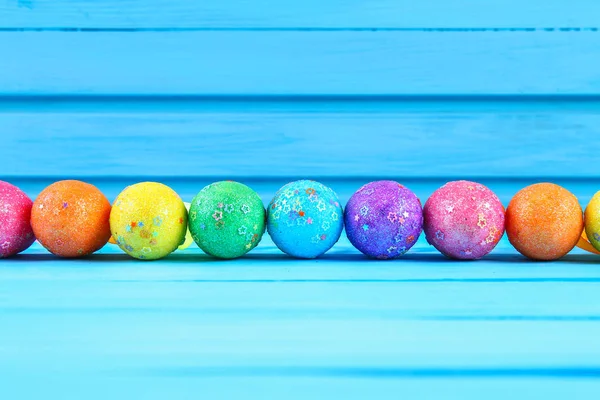 Ovo de Páscoa colorido no fundo de madeira de cor pastel azul com espaço — Fotografia de Stock