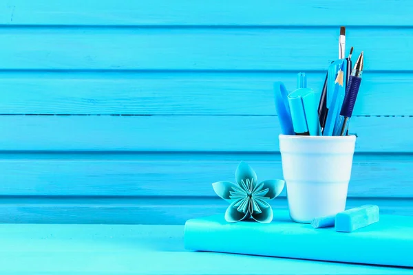 Libro azul y papelería sobre una mesa de madera azul. Educación, estudios . —  Fotos de Stock