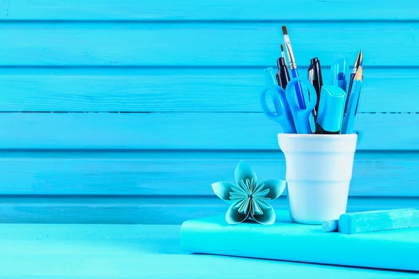 Libro azul y papelería sobre una mesa de madera azul. Educación, estudios . —  Fotos de Stock