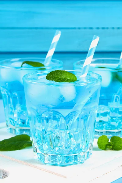 Kék jég és a menta a pohár a kék tábla fehér fából készült táblán koktél. — Stock Fotó