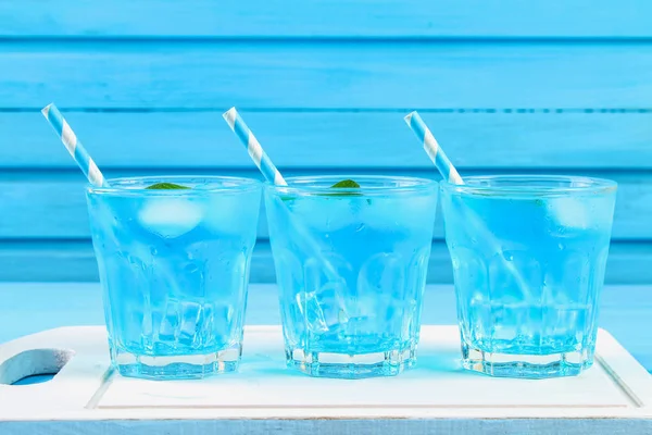 Kék jég és a menta a pohár a kék tábla fehér fából készült táblán koktél. — Stock Fotó
