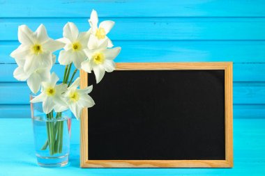 Nergis çiçek ve ahşap arka plan, kopya alanı etiketinde boş yazı tahtası.