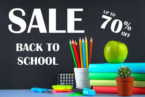 A pile of books and stationery on a chalkboard background. Work desk, education, school. SALE. — Stock Photo, Image