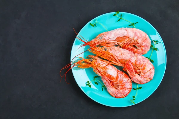 Grandes langostinos congelados reales en un plato azul con tomillo y albahaca sobre una mesa de hormigón. Camarones rojos. Vista superior . — Foto de Stock