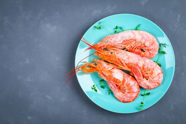 Grandes langostinos congelados reales en un plato azul con tomillo y albahaca sobre una mesa de hormigón. Camarones rojos. Vista superior . — Foto de Stock