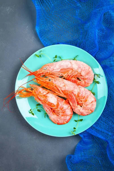 Grandes langostinos congelados reales en un plato azul con tomillo y albahaca sobre una mesa de hormigón. Camarones rojos. Vista superior . — Foto de Stock