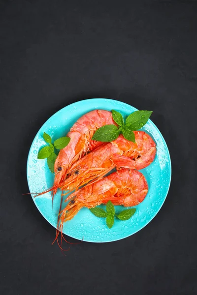 Grandes langostinos congelados reales en un plato azul con tomillo y albahaca sobre una mesa de hormigón. Camarones rojos. Vista superior . — Foto de Stock