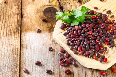 Ahşap bir masa üzerinde yeşillikleri ile ham Barbunya.