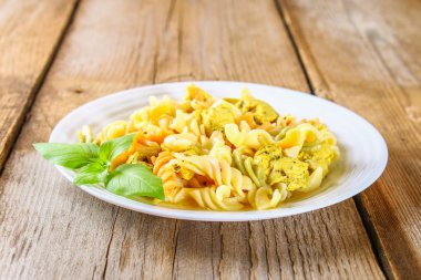 Makarna dilim kızarmış tavuk fileto eski ahşap masa.