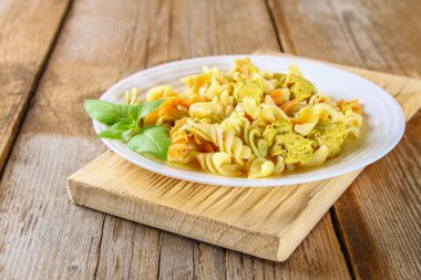 Makarna dilim kızarmış tavuk fileto eski ahşap masa.