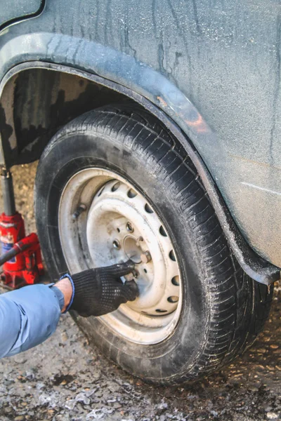 Substituindo porcas de alça à mão enquanto troca pneus em um veículo . — Fotografia de Stock