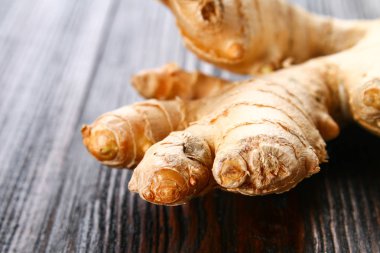 Baharatlı kök zencefil ahşap bir masa üzerinde.