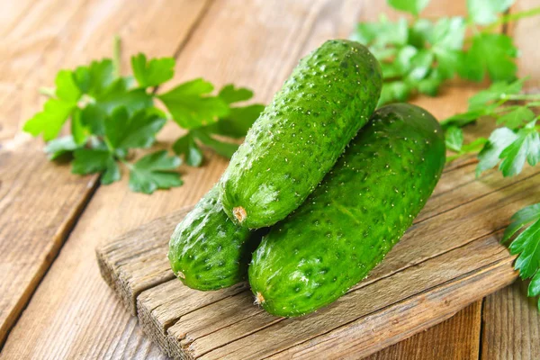 Fresh green homemade cucumber with parsley on an old wooden table. — Stock Photo, Image