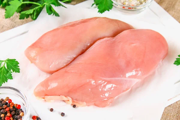 Raw chicken fillets on wooden cutting board. — Stock Photo, Image
