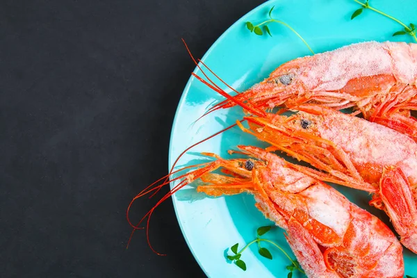 Grandes langostinos congelados reales en un plato azul con tomillo y albahaca sobre una mesa de hormigón. Camarones rojos. Vista superior . — Foto de Stock