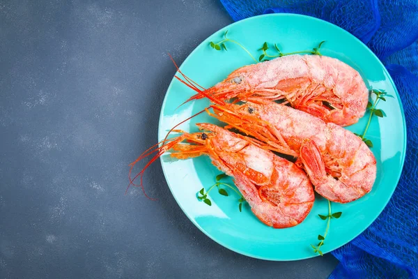 Grandes langostinos congelados reales en un plato azul con tomillo y albahaca sobre una mesa de hormigón. Camarones rojos. Vista superior . — Foto de Stock