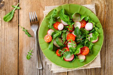 Roka, domates, turp ve mozzarella peyniri eski ahşap masa vejetaryen salata.