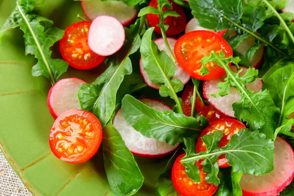 Vegetarian salad of arugula, tomato, radish and mozzarella cheese on an old wooden table. — Stock Photo, Image