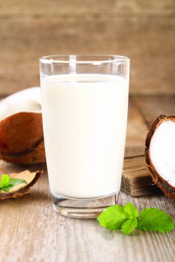 Hindistan cevizi ve Hindistan cevizi sütü cam, ahşap eski masanın üzerine nane.