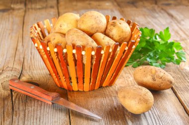 Sarı patates yumrular eski ahşap masa.