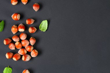 Doymuş bir siyah arka plan üzerine üstten görünüm kavrulmuş soyulmuş fındık. Abur cubur. Kopya alanı