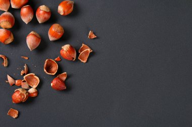 Doymuş bir siyah arka plan üzerine üstten görünüm kavrulmuş soyulmuş fındık. Abur cubur. Kopya alanı