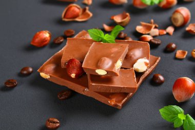 Çikolata fındık, nane ve koyu gri masada kahve taneleri