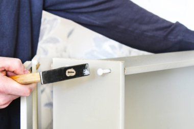 Bir adam çekmeceler için bir çekmece toplar. Mobilya montajı. Mobilyaları karantinaya alın..