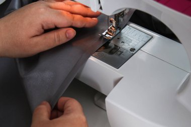 Bir adam dikiş makinesinin perdesini araladı. Dikiş dikmek, hobiler, hobiler, ev dekorasyonu..