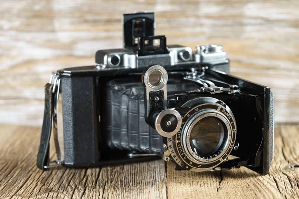 dokulu bir rustik ahşap yüzey üzerinde eski katlama fotoğraf makinesi.