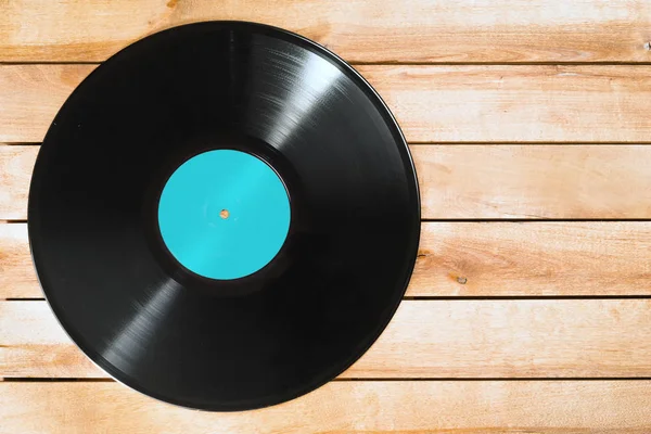 Record plate on wooden background — Stock Photo, Image