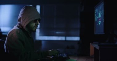 Karanlık odada oturan bilgisayar korsanı 