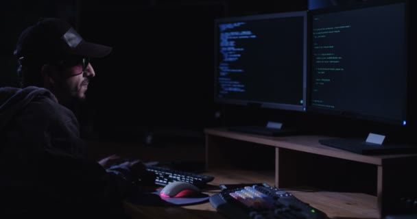 Počítačový hacker sedí v temné místnosti 