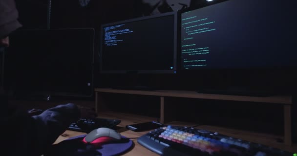 Computer hacker sitting in dark room — Stock Video