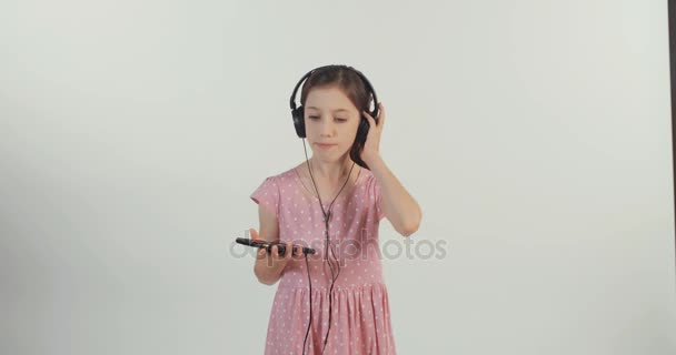 女の子のヘッドフォンで音楽を聴く — ストック動画