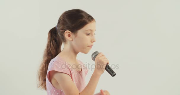 Маленькая девочка поет с микрофоном — стоковое видео