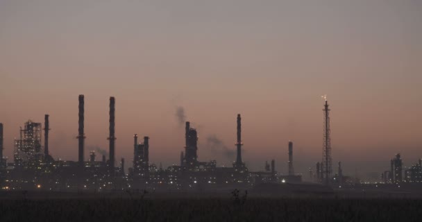 Grote olie raffinaderij silhouet tegen de zonsopgang. — Stockvideo